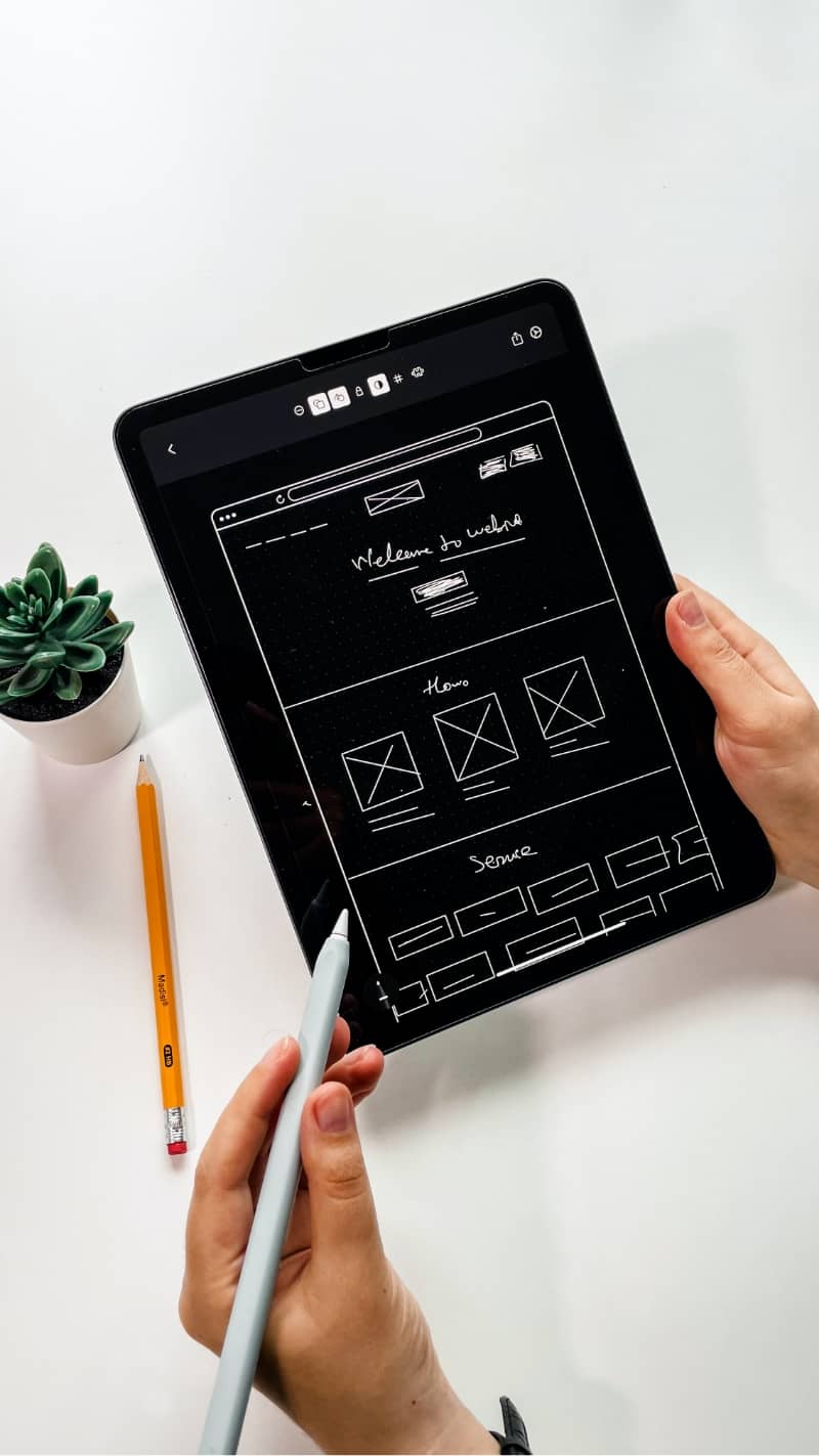 An image of a designer creating UX wireframes on an iPad
